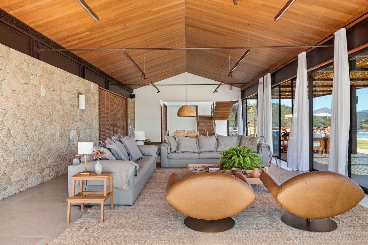 SALA DE ESTAR | A arquitetura contemporânea conversa com a paisagem natural, vista pelas grandes...
