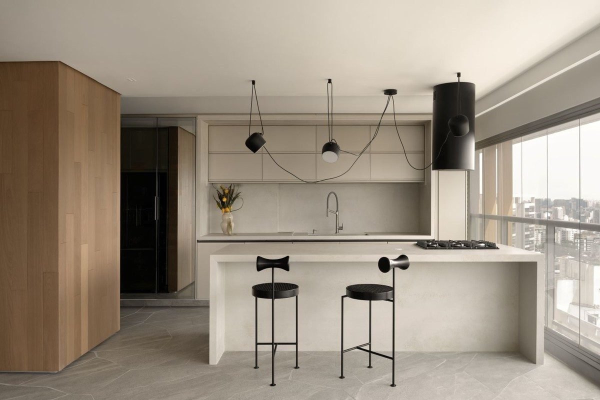 A marcenaria em laca off-white, executada pela Dell Anno Atelier, se integra à pedra Coverlam Cr...